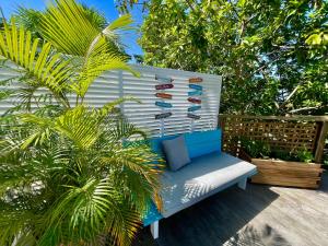 a blue and white bench sitting on a deck with palm trees at Villa Orsalina Pointe Batterie in Deshaies
