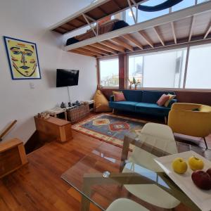 a living room with a blue couch and a table at Casa Sonho Azores - AL 1449 in Ponta Delgada