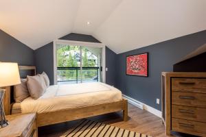 a bedroom with a bed and a window at Renovated Lynx Property - Spacious 4 bedroom with private balcony and hot tub! in Whistler