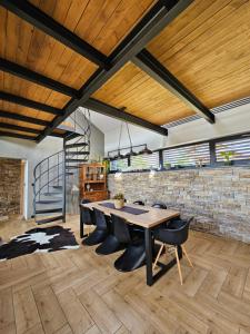 a dining room with a table and chairs and a brick wall at Vila Leo in Donovaly