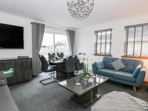 a living room with a blue couch and a table at The Bungalow in Maybole