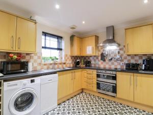 a kitchen with yellow cabinets and a washer at The Bungalow in Maybole
