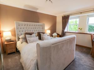 a bedroom with a large bed and a window at The Bungalow in Maybole