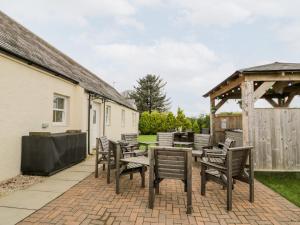a patio with chairs and a table and a gazebo at The Bungalow in Maybole