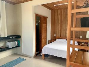 a bedroom with a bed and a bunk bed at Vila Guaiamum in Cumuruxatiba