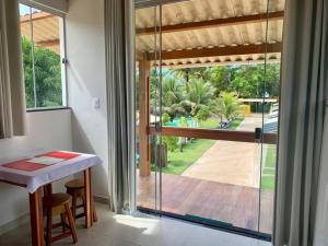 a room with a table and a view of a patio at Vila Guaiamum in Cumuruxatiba