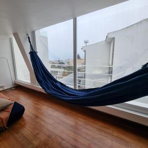 a hammock in a room with a large window at Casa Sonho Azores - AL 1449 in Ponta Delgada