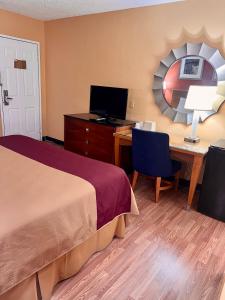 a hotel room with a bed and a desk with a computer at Executive Inn Schenectady Downtown in Schenectady