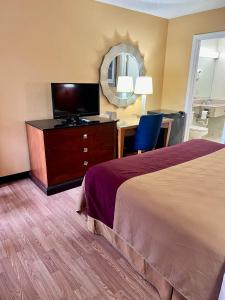 a hotel room with a bed and a desk and a television at Executive Inn Schenectady Downtown in Schenectady