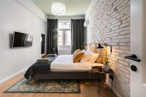 a bedroom with a bed and a brick wall at Old City Apartment in Bucharest