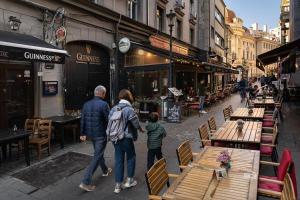 a man and woman walking down a street with a child at Old City Apartment in Bucharest