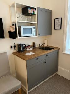 a kitchen with a counter with a sink and a microwave at Little Gem in Kemptown Brighton in Brighton & Hove