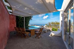 a patio with a table and chairs and a swimming pool at 270 Oias View in Oia