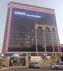 a building with cars parked in front of it at In Taibah in Medina