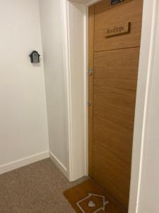 a room with a wooden door with a sign on it at Rooftops Apartment in Bletchley