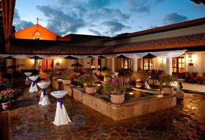 a lobby with potted plants and flowers in a building at Exquisite 3BR Condo Ocean Views Access Resorts in Cabo San Lucas