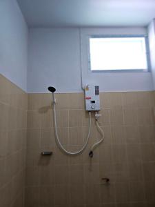 La salle de bains est pourvue d'une douche et d'une fenêtre. dans l'établissement Ban Chahomm Guesthouse, à Betong