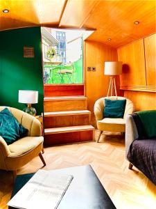 a living room with two chairs and a table at The Four Sisters Boatel - Houseboat in Edinburgh