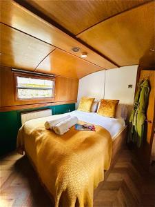 a bedroom with a bed in the back of a boat at The Four Sisters Boatel - Houseboat in Edinburgh