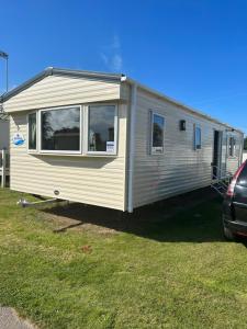 a mobile caravan is parked in a yard at Parkdean cherry tree holiday park Burgh castle Great Yarmouth in Belton
