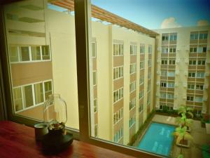 a room with a window with a view of a building at Stanford Suites, South Forbes - Standard Room with pool in Silang