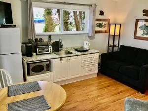 a kitchen with a couch and a sink and a microwave at Telco House B&B in Port Hardy