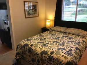 1 dormitorio con 1 cama con colcha de flores en Telco House B&B en Port Hardy