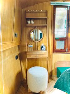 Habitación pequeña con taburete y espejo en The Four Sisters Boatel - Houseboat, en Edimburgo