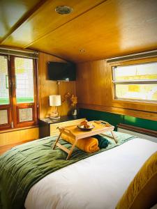 a dog laying on a bed with a table on it at The Four Sisters Boatel - Houseboat in Edinburgh