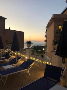 a group of lounge chairs on the roof of a building at Hotel Villa Maria in Sorrento