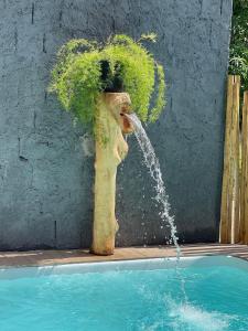 a water fountain in the middle of a swimming pool at Flats da Ilha 2 Quartos in Marechal Deodoro