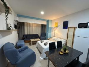 a living room with a bed and a table and chairs at Castellano de SteraM Flats Torremolinos in Torremolinos