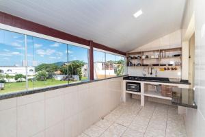 cocina con ventanas grandes y vistas al campo en Ala Tainha - Residencial Solavir, en Bombinhas