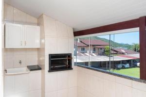 cocina con chimenea y ventana grande en Ala Tainha - Residencial Solavir, en Bombinhas