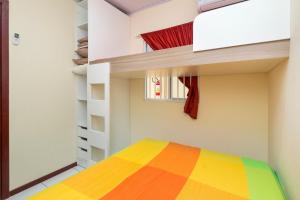 1 dormitorio con cama de arco iris y ventana en Ala Tainha - Residencial Solavir, en Bombinhas