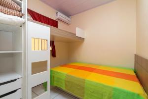 1 dormitorio con cama de arco iris y literas en Ala Tainha - Residencial Solavir, en Bombinhas