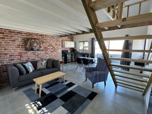 uma sala de estar com um sofá e uma parede de tijolos em Modern apartments downtown em Plettenberg Bay