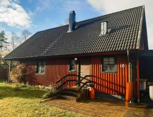 une maison rouge avec un toit noir dans l'établissement Vakantiewoning in Småland Zuid-Zweden, à Hjältevad