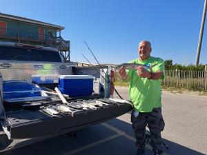 um homem segurando um peixe na traseira de um caminhão em Sea Vista Motel em Topsail Beach