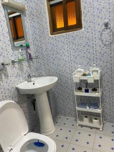bagno con servizi igienici bianchi e lavandino di Residence Adja Binta Kane Sour a Dakar