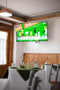 a dining room with a table and a television on the wall at Hostería Las Rosas in Esquel