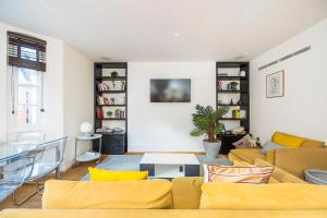 ein Wohnzimmer mit einem Sofa und einem Tisch in der Unterkunft Lux Duplex near Oxford St in London