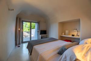 a bedroom with a large bed and a balcony at 270 Oias View in Oia