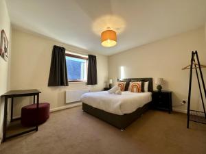 a bedroom with a large bed and a window at Super Apartment next to Bicester Village Sleeps 4 in Bicester