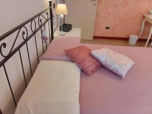ローマにあるItaly's enchanting ambiance - A snug apartment in Romeの階段の上にピンクと白の枕が付いたベッド