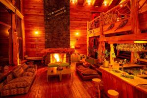 a living room with a fireplace in a log cabin at Patagonia Lodge in Las Trancas