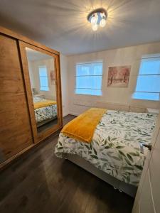 ein Schlafzimmer mit einem Bett und einem großen Spiegel in der Unterkunft Stylish 2 Bedroom Semi-Detached House in Leicester in Leicester