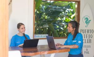 twee vrouwen aan een tafel met hun laptops bij Puerto Viejo Club, Villa & pool for 6 pax in Puerto Viejo