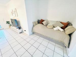 a living room with a couch and a tiled floor at Homely - modern - für 4 - Boxspringbetten - Internet in Philippsburg