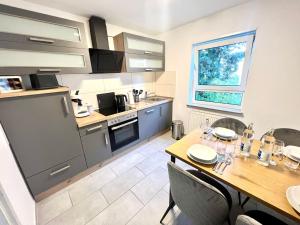 a kitchen with a wooden table with chairs and a dining room at Homely - modern - für 4 - Boxspringbetten - Internet in Philippsburg